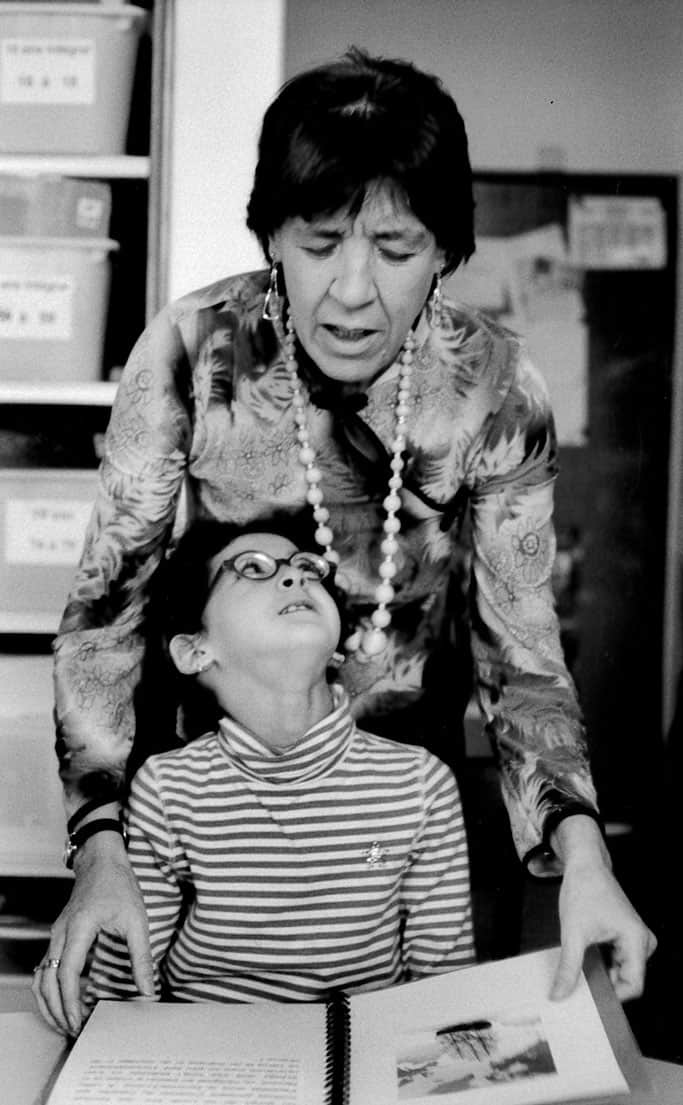 Photo d'Olga d'Amore et d'un enfant lisant ensemble un texte en braille