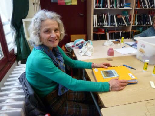 Photo de Véronique collant face à face les pages en braille et en gros caractères