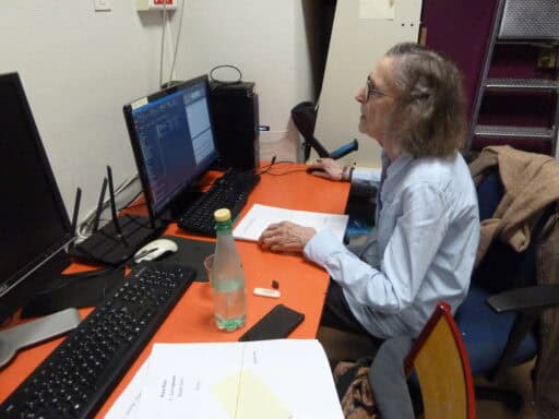 Photo de Marie-France contrôlant sur page par page la correspondance braille/gros caractères